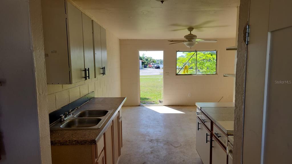 A kitchen with light-colored cabinets, a double sink, and a door leading to the outdoors — 2222 W SOUTH STREET UNIT 2203, ORLANDO, FL