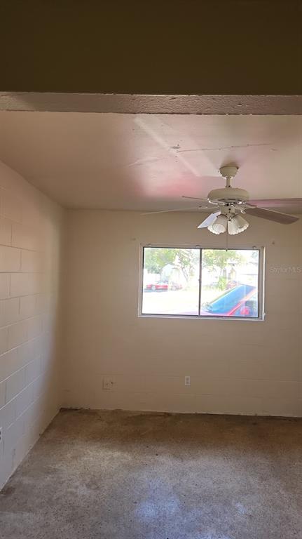 An interior room features white painted block walls, a ceiling fan, and a concrete floor — 2222 W SOUTH STREET UNIT 2203, ORLANDO, FL