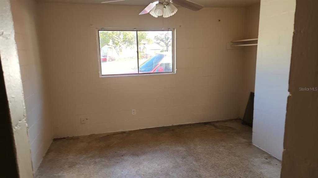 An unfinished room features exposed concrete block walls, a concrete floor, and a ceiling fan — 2222 W SOUTH STREET UNIT 2203, ORLANDO, FL