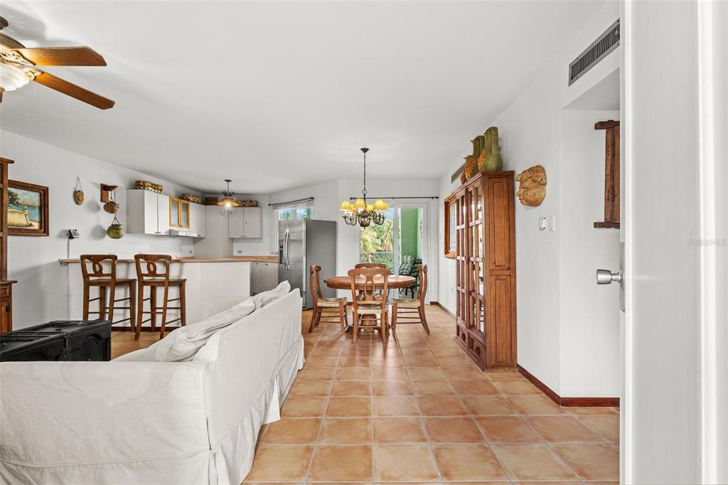 An open-concept living and dining area features tile flooring, a kitchen, and a wooden hutch — 195 CANDELERO DRIVE UNIT 6232, HUMACAO, PR