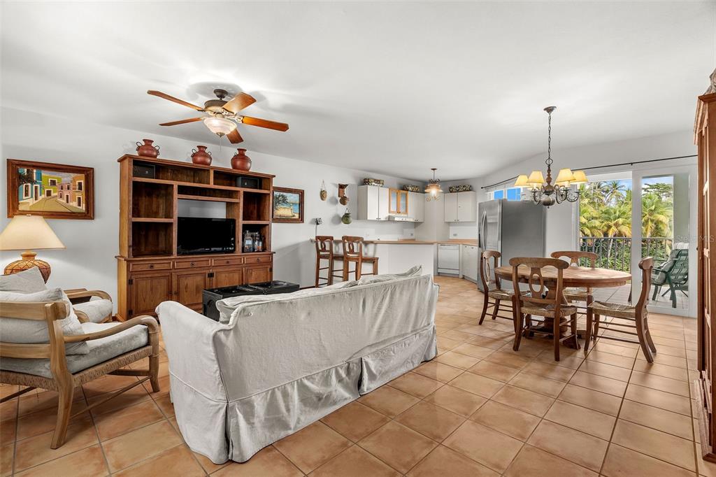 An open-concept living and dining area with tile flooring, a wooden entertainment center, and balcony — 195 CANDELERO DRIVE UNIT 6232, HUMACAO, PR