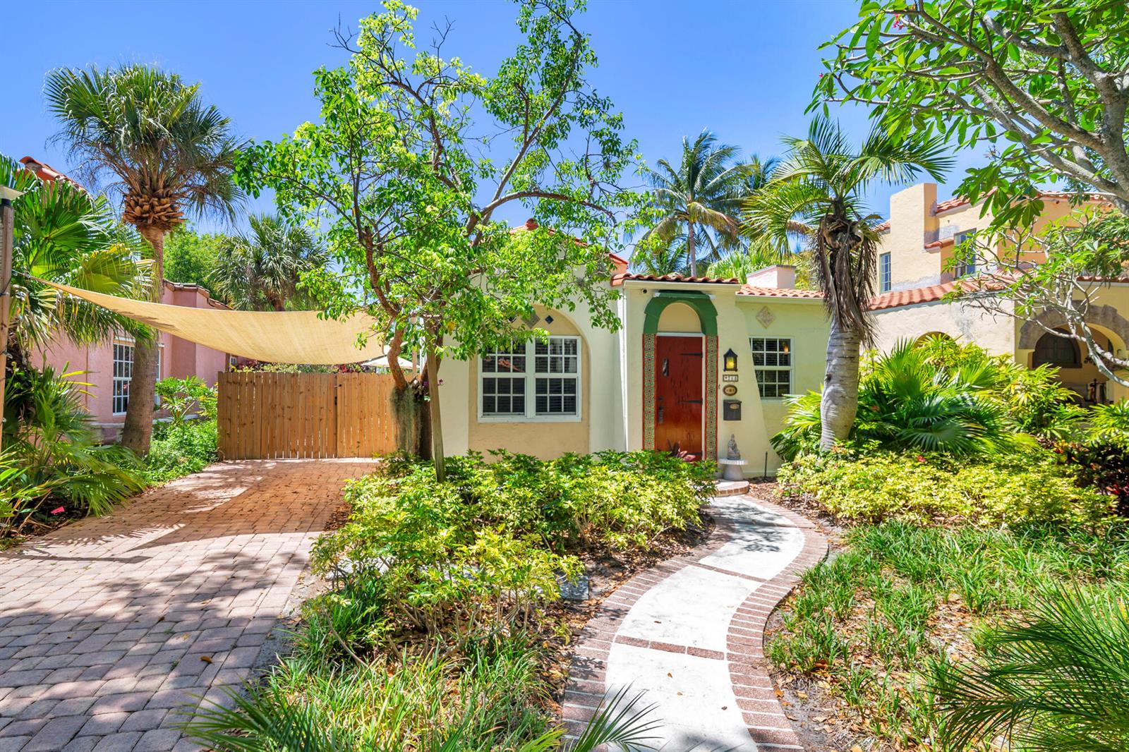 A single-story stucco house with a red door, brick driveway, and a curved walkway — 714 Sunset Road, West Palm Beach FL 33401, WEST PALM BEACH, FL
