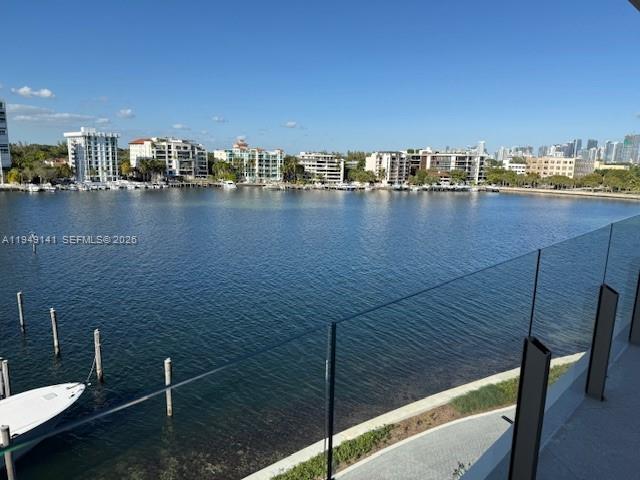 A view of a bay and city skyline from a balcony with glass railings — 5 Grove Isle Dr. # S503, Miami FL 33133, MIAMI, FL