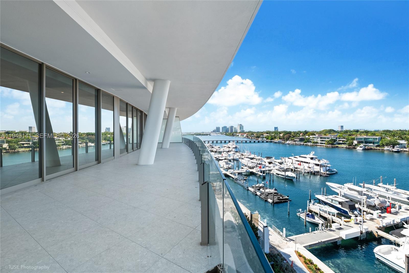 A wide balcony with glass railings overlooks a marina filled with boats — 5 Grove Isle Dr. # S503, Miami FL 33133, MIAMI, FL