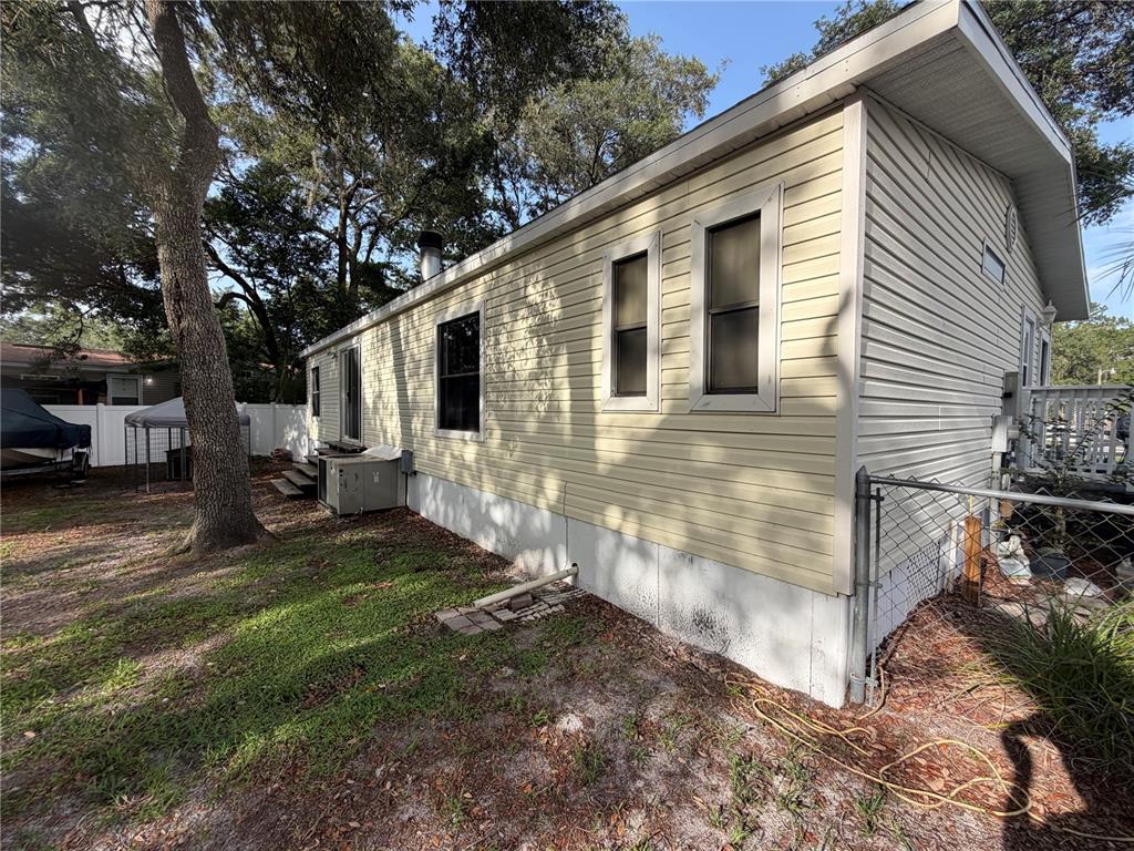 The exterior of a light yellow manufactured home features vinyl siding and a white skirting — 40235 OVERLOOK DRIVE, EUSTIS, FL