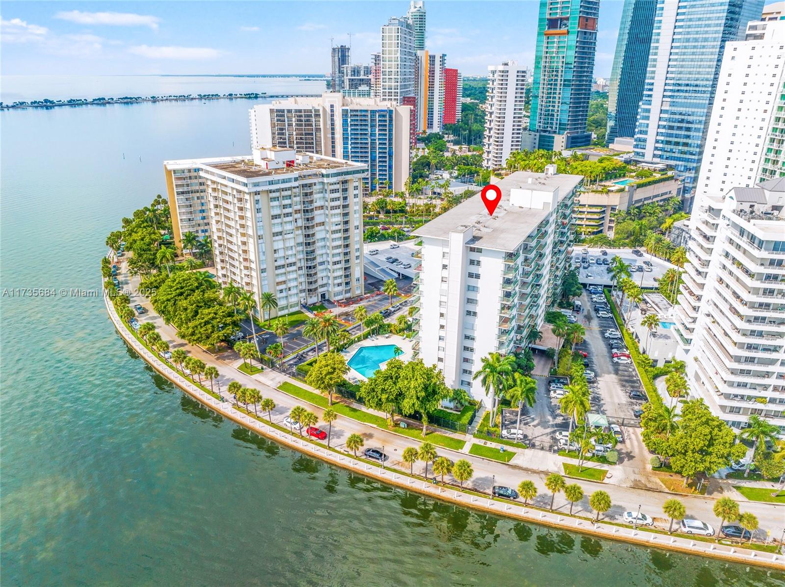 A kitchen features wood-grain cabinets, white tile countertops, a black dishwasher, and a black cooktop — 1408 Brickell Bay Dr # 917, Miami FL 33131, MIAMI, FL