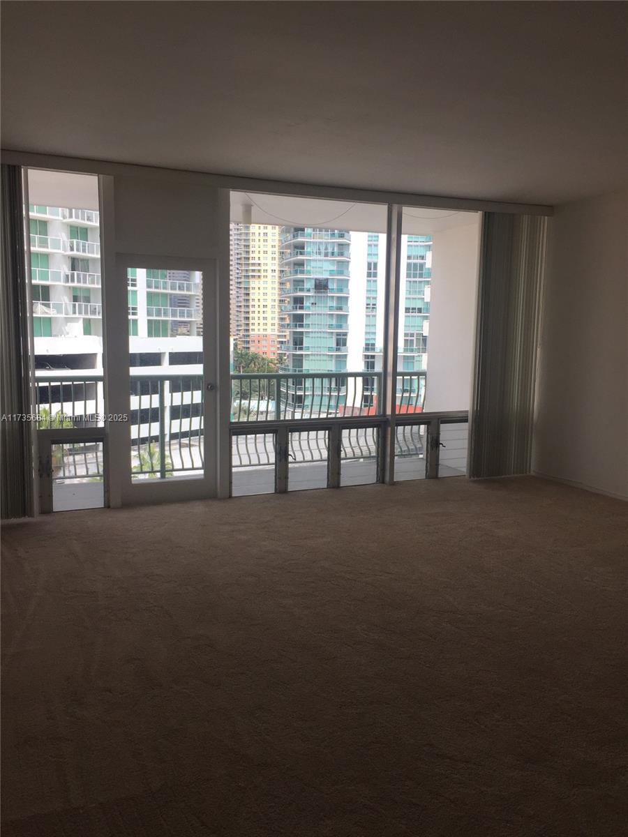A kitchen features wood-grain cabinets, a white wall oven, and white tiled countertops — 1408 Brickell Bay Dr # 917, Miami FL 33131, MIAMI, FL