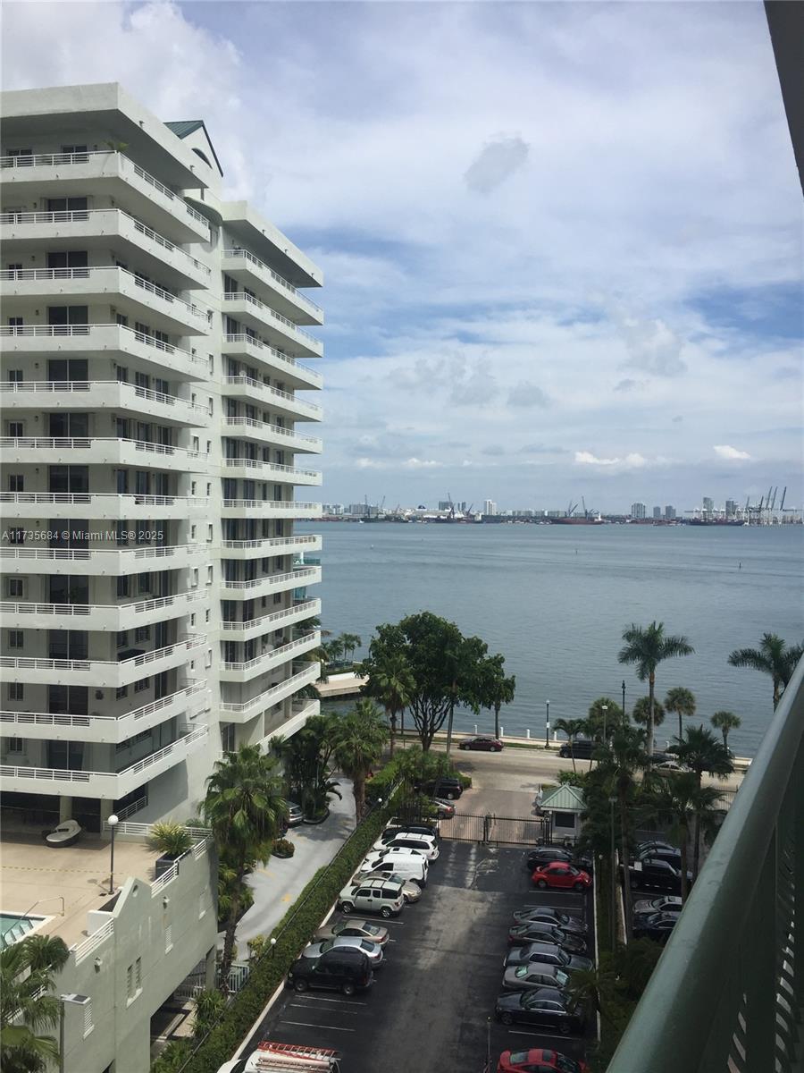 A balcony with a gray floor, green metal railing, and a view of the ocean — 1408 Brickell Bay Dr # 917, Miami FL 33131, MIAMI, FL