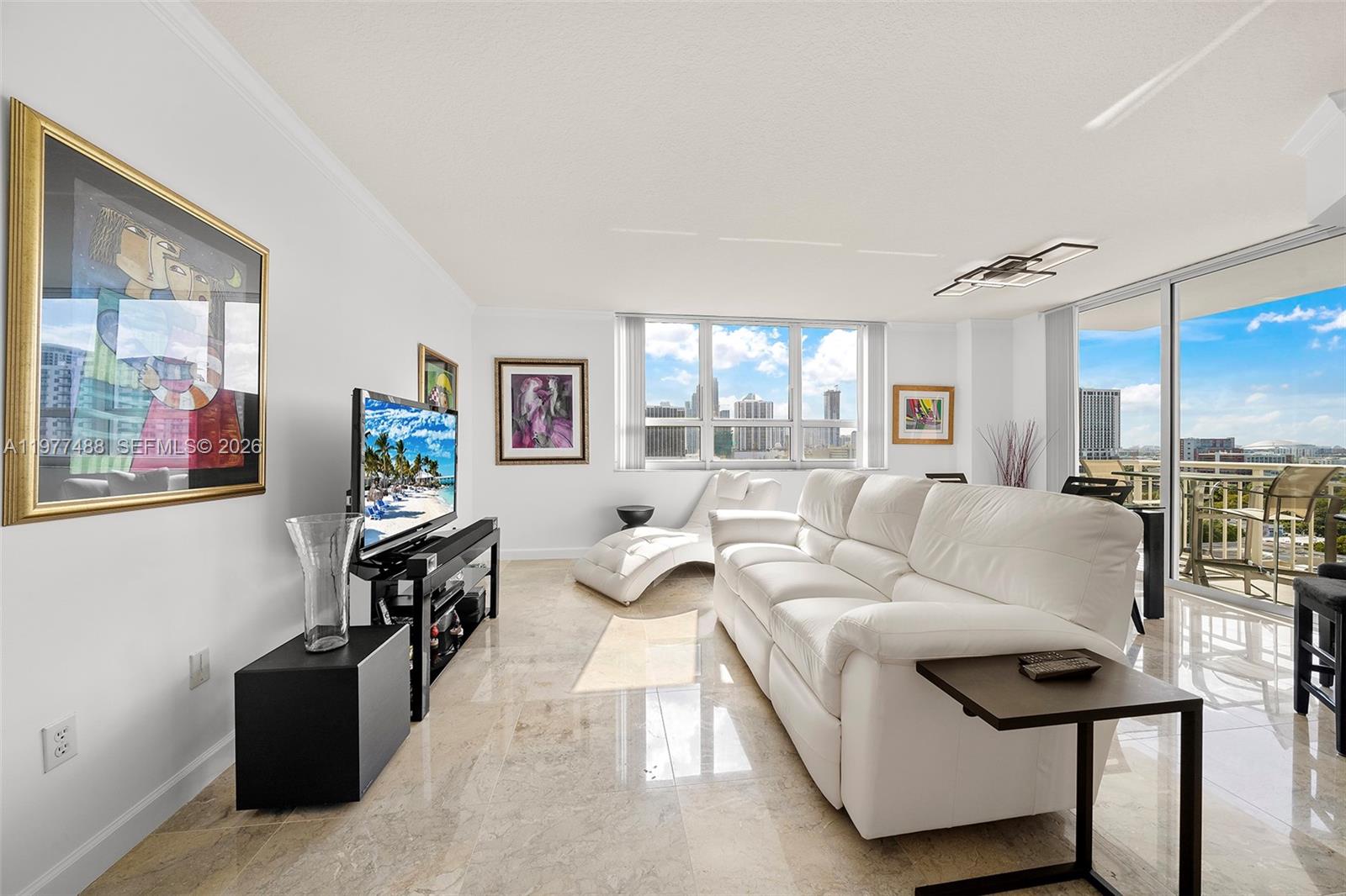 A bright living room features white leather seating, marble floors, and a balcony with city views — 2000 N Bayshore Dr # 1502, Miami FL 33137, MIAMI, FL