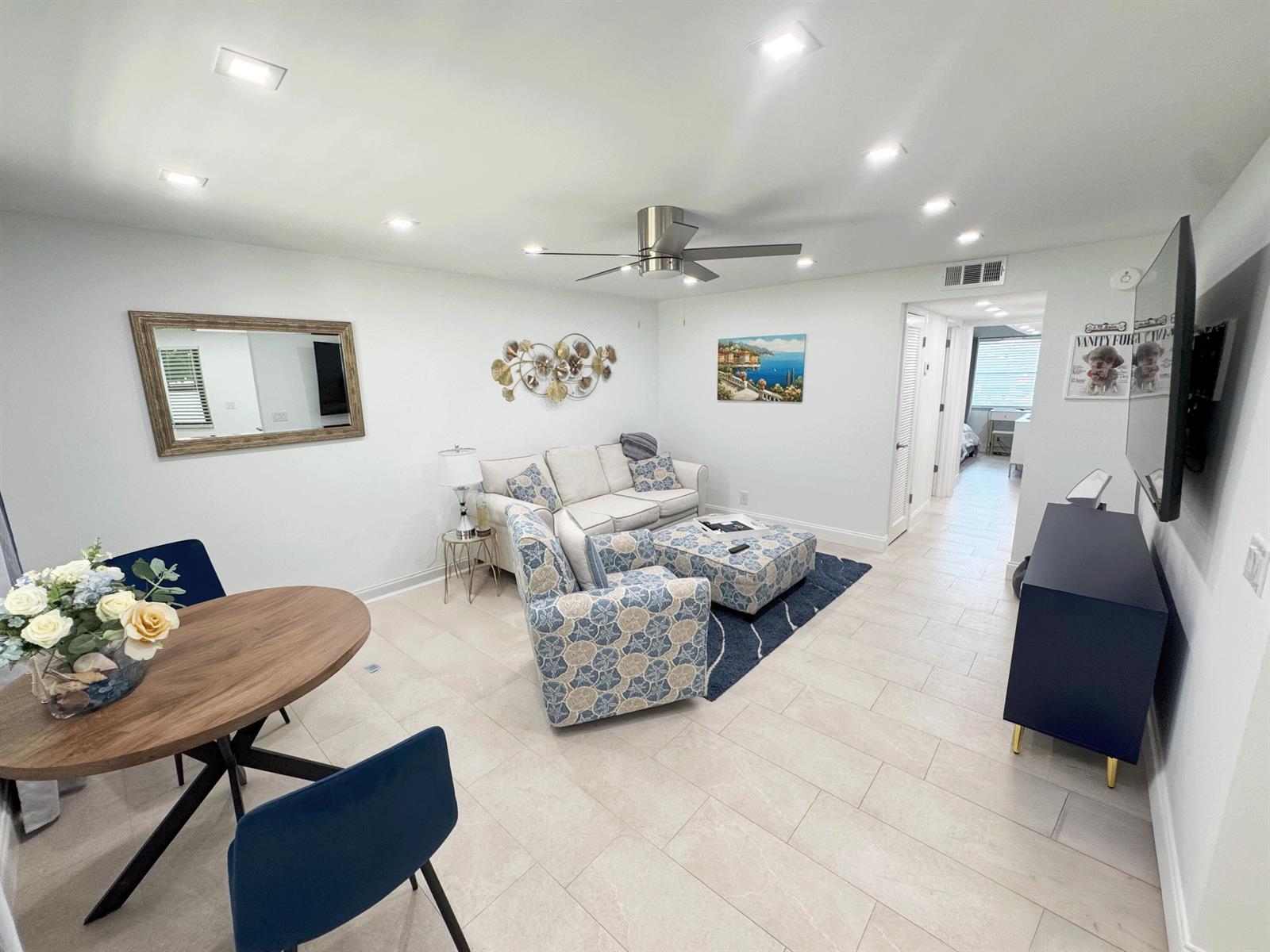 A living room features a blue patterned armchair, a white sofa, and a dining table — 18 Piedmont A, Delray Beach FL 33484, DELRAY BEACH, FL