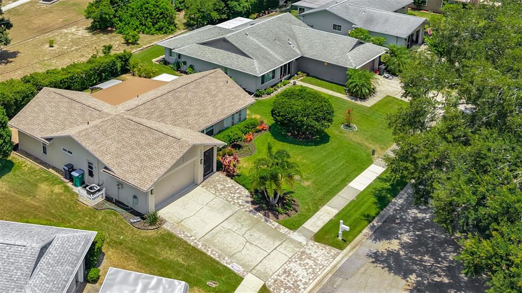 An aerial view shows two suburban houses with shingled roofs, driveways, and landscaped lawns — 2632 CAMILLE DRIVE, PALM HARBOR, FL