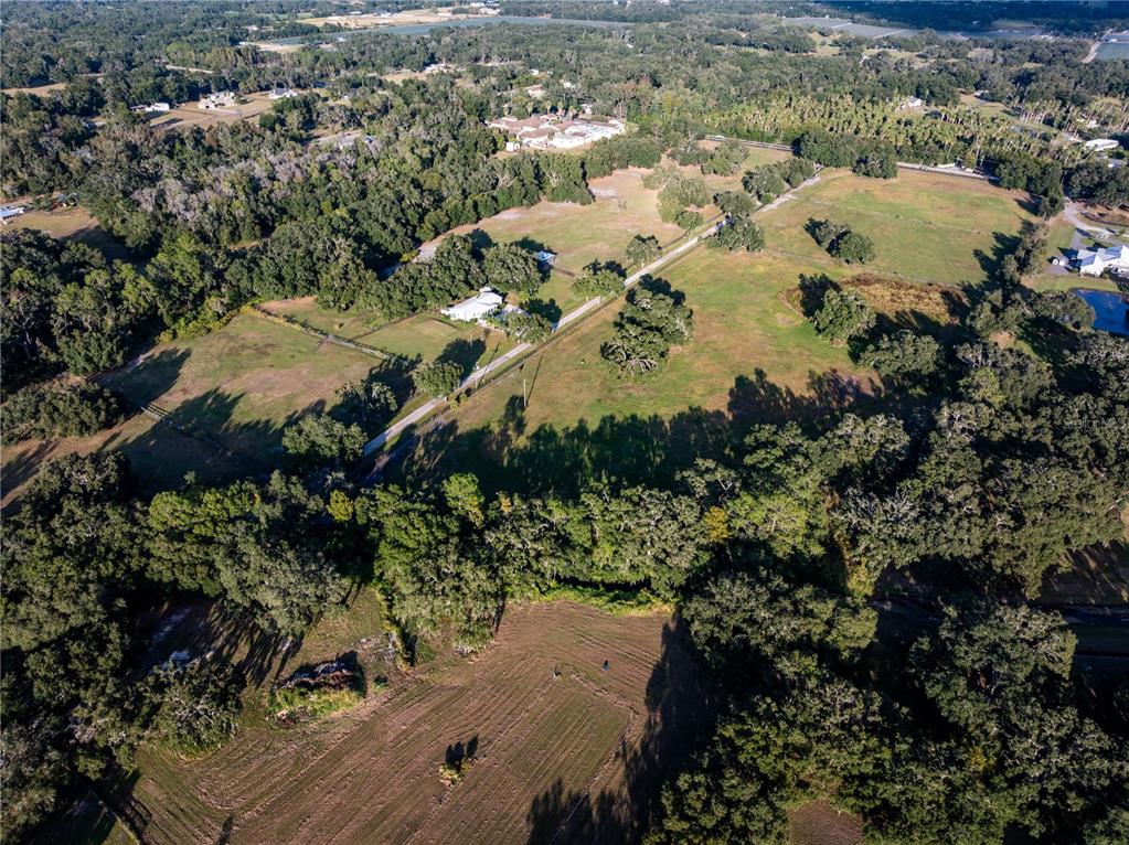 An aerial view shows a rural property with pastures, scattered trees, and a small house — 12537 TOMAR DRIVE, THONOTOSASSA, FL