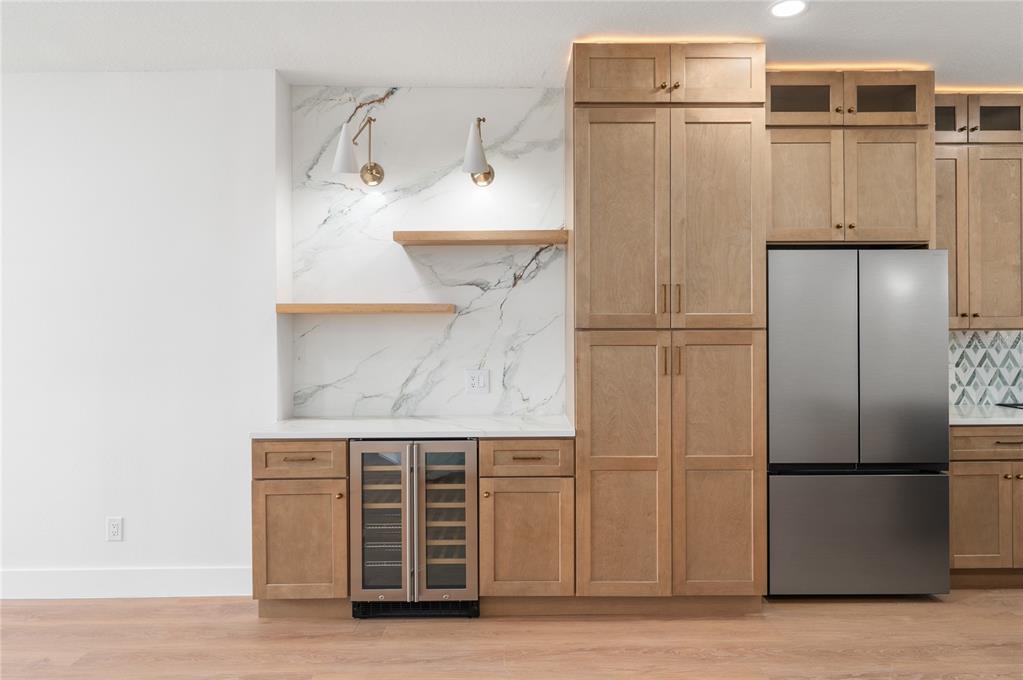 A kitchen features light wood cabinets, a marble backsplash, floating shelves, and a wine refrigerator — 2424 STONE CROSS CIRCLE, ORLANDO, FL