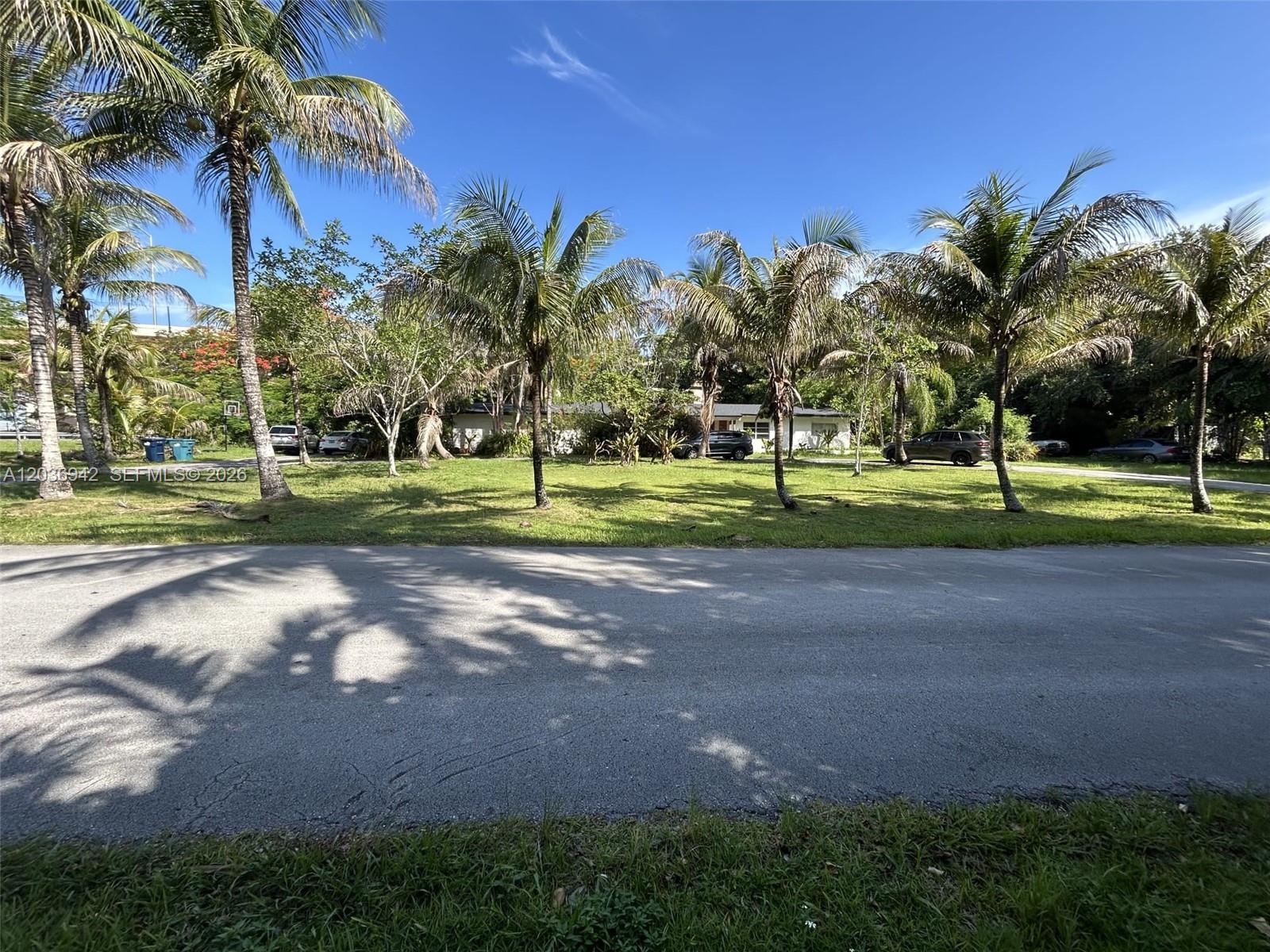 A residential house sits behind a large grassy lawn filled with numerous palm trees — 8603 SW 68th St Rd, Miami FL 33143, MIAMI, FL