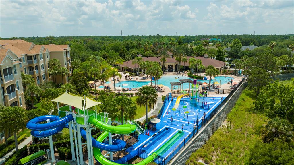 An aerial view shows a resort swimming pool area with water slides and a splash pad — 2813 ALMATON LOOP UNIT 301, KISSIMMEE, FL