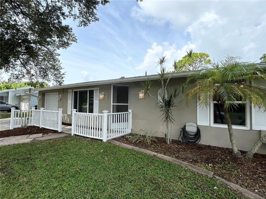 A single-story house with a beige exterior, white shutters, and a white picket fence — 4485 COSTELLO STREET, PORT CHARLOTTE, FL