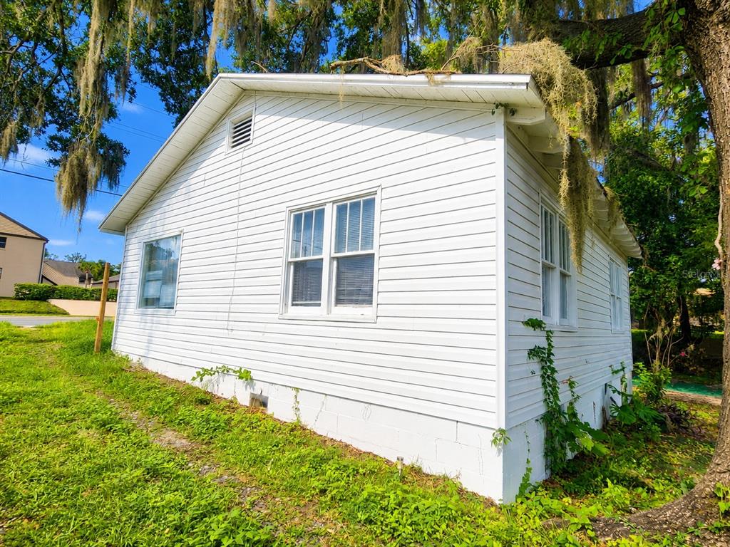 An exterior view of a white, single-story house with horizontal siding and a block foundation — 617 NE 25TH AVENUE, OCALA, FL
