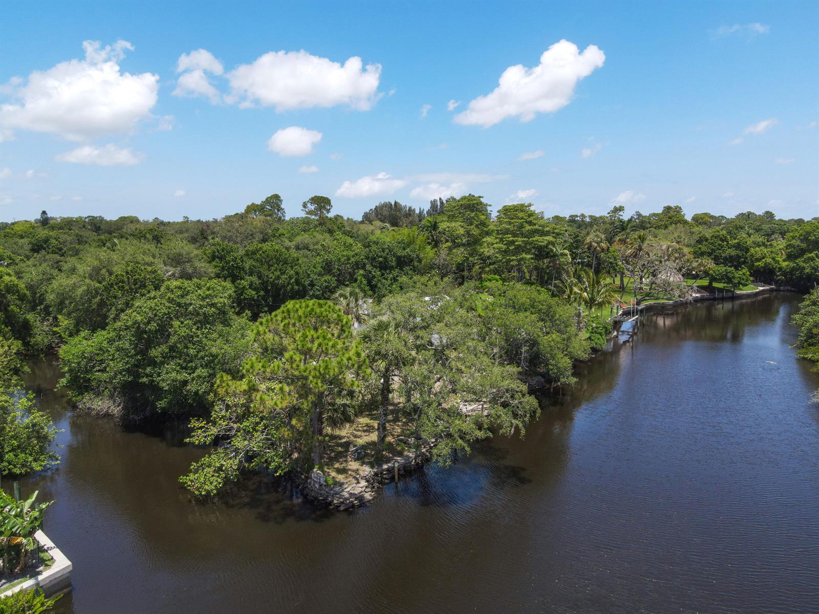 An aerial view shows a wooded property situated at the junction of a dark river — 332 SW Salerno Road, Stuart FL 34997, STUART, FL