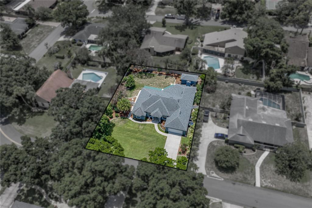 An aerial view shows a single-story house with a gray roof and a concrete driveway — 1113 SUGARTREE DRIVE N, LAKELAND, FL