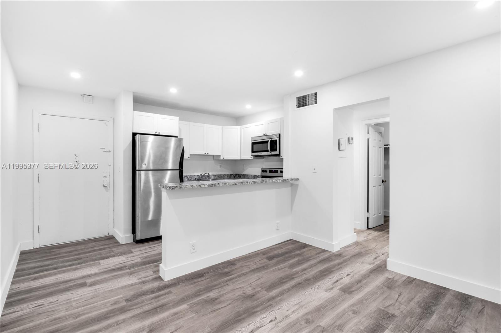 A kitchen with stainless steel appliances, white cabinets, and a breakfast bar — 6445 NW 2nd Ave # 2, Miami FL 33150, MIAMI, FL