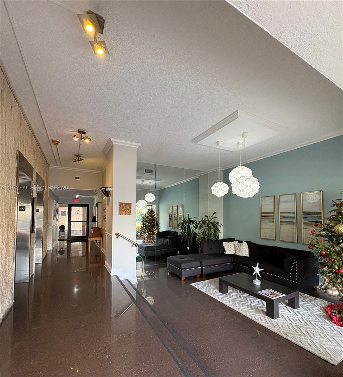 A lobby features a dark tiled floor, a black sectional sofa, and a Christmas tree — 3500 NE 135 # 502, North Miami FL 33181, NORTH MIAMI, FL