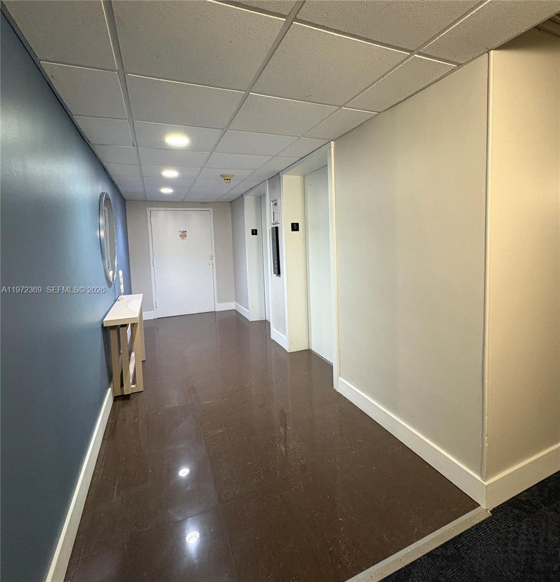 A hallway features a blue accent wall, a console table, and two elevator doors — 3500 NE 135 # 502, North Miami FL 33181, NORTH MIAMI, FL
