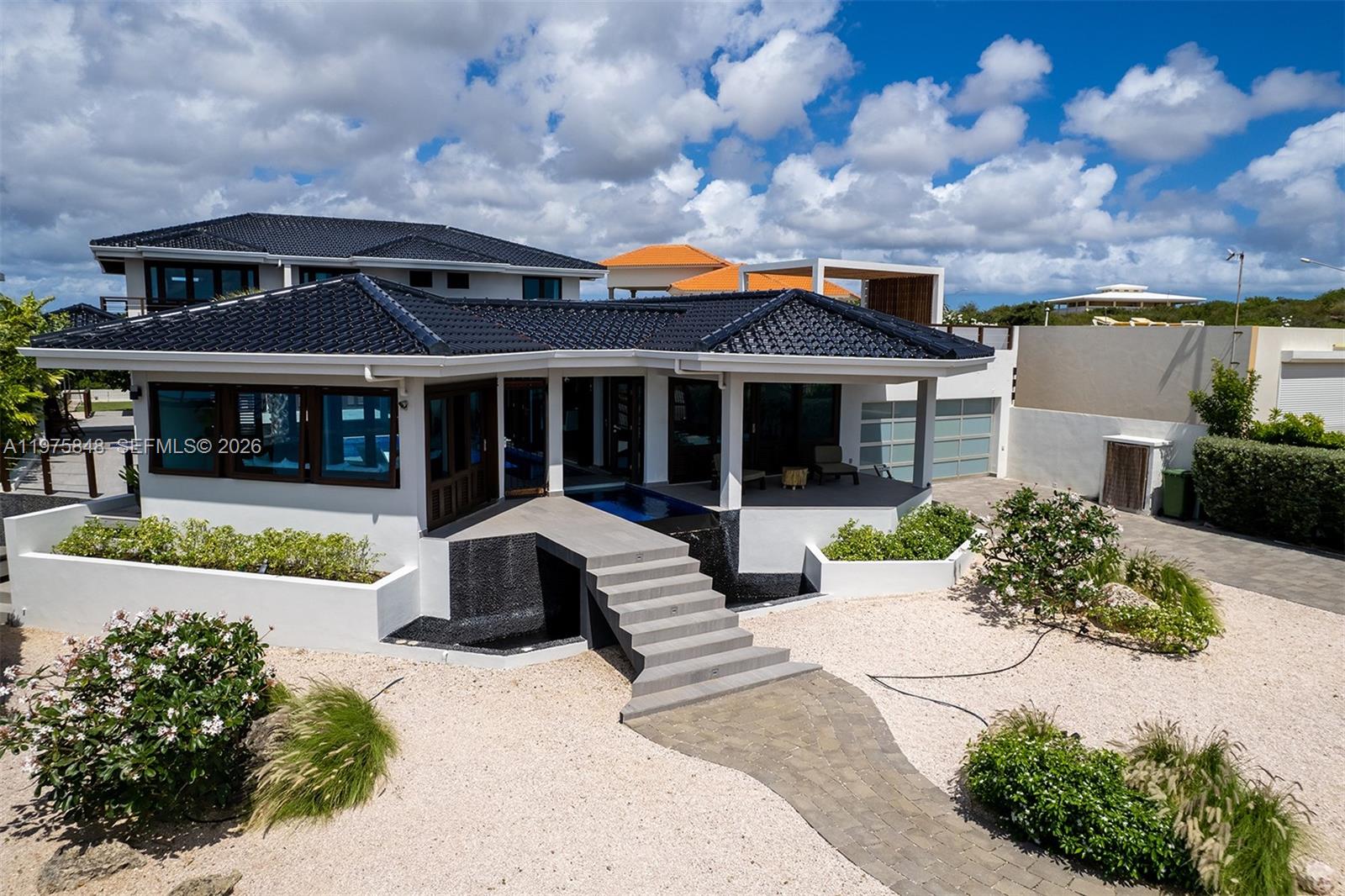 A modern house with a dark tiled roof, a central staircase, and a water feature — T17 Vista Royal, FL 0000, FL