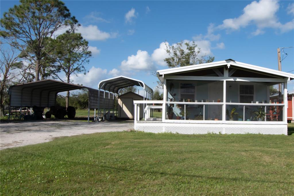 A single-story house with a screened porch, a metal carport, and a small storage shed — 3364 N MARINA PARKWAY, LAKE WALES, FL