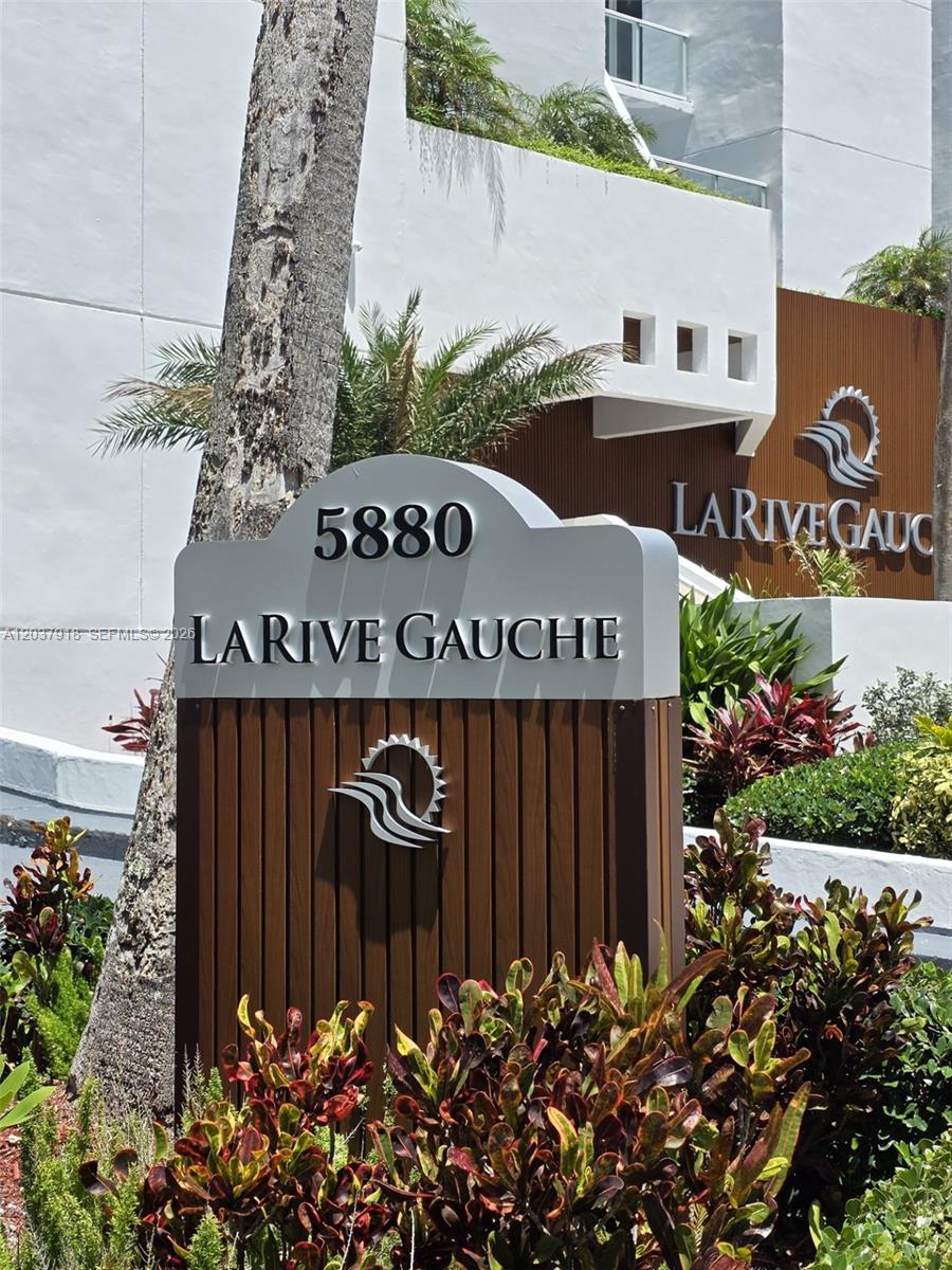 A sign for La Rive Gauche stands in front of a white building with landscaping — 5880 Collins Ave # 302, Miami Beach FL 33140, MIAMI BEACH, FL