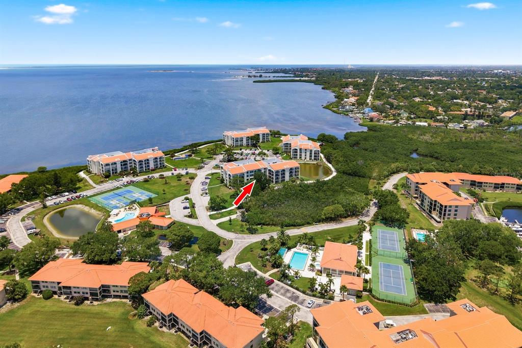 An aerial view of a waterfront condominium complex with multiple buildings, pools, and tennis courts — 125 MARINER DRIVE UNIT 125, TARPON SPRINGS, FL