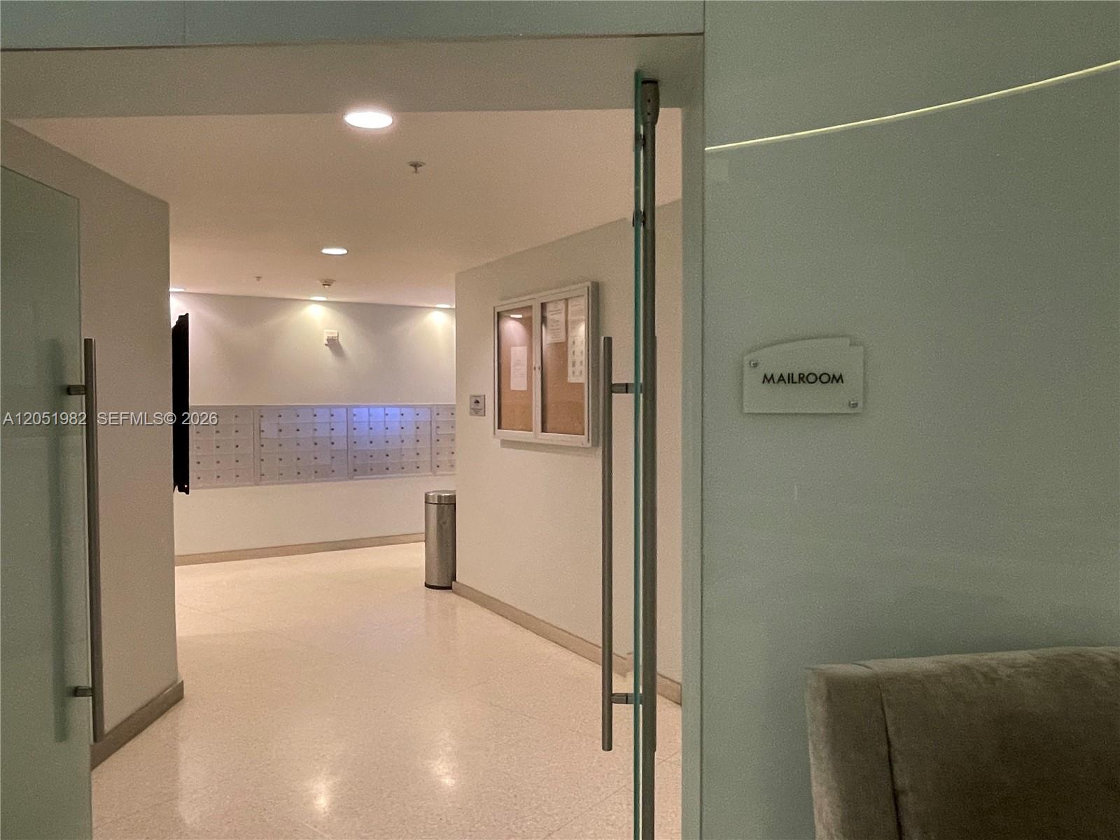 A glass door opens into a mailroom featuring rows of metal mailboxes and a bulletin board — 92 SW 3rd St # 5012, Miami FL 33130, MIAMI, FL
