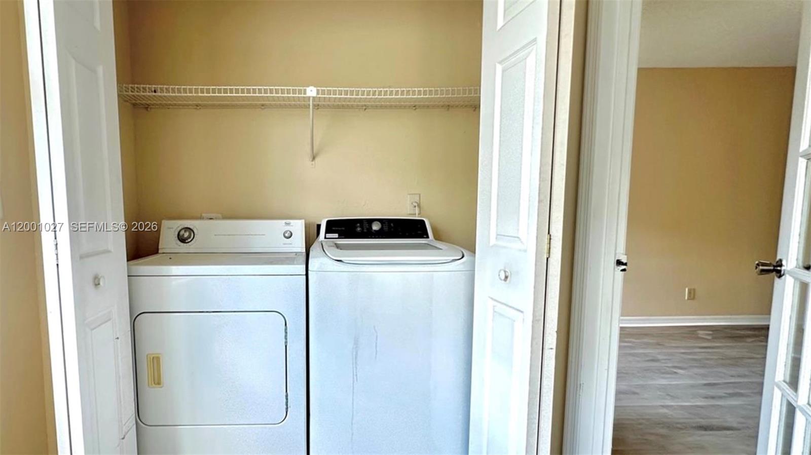 A laundry closet contains a white top-loading washing machine and a front-loading dryer — 3310 N Pinewalk Dr N # 1823, Margate FL 33063, MARGATE, FL