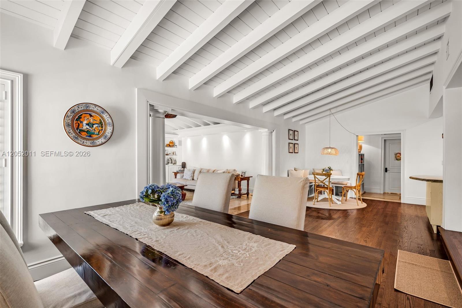 A dining room with a dark wood table and vaulted white beamed ceilings — 168 Morningside Dr, Coral Gables FL 33133, CORAL GABLES, FL