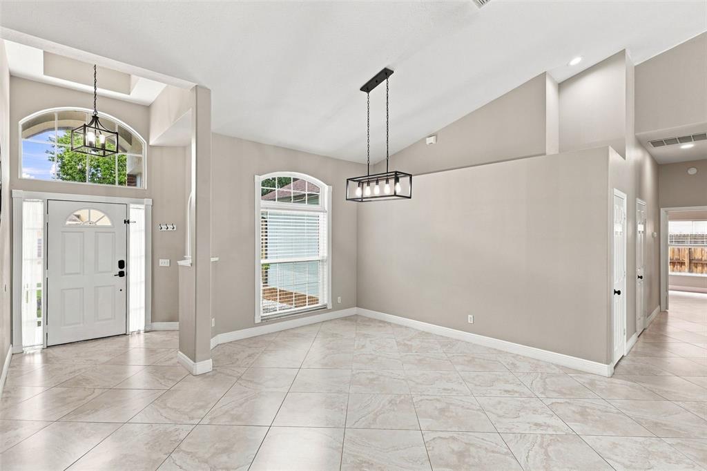 A bright dining area features vaulted ceilings, tile flooring, a rectangular chandelier, and arched windows — 3716 GATLIN PLACE CIRCLE, ORLANDO, FL
