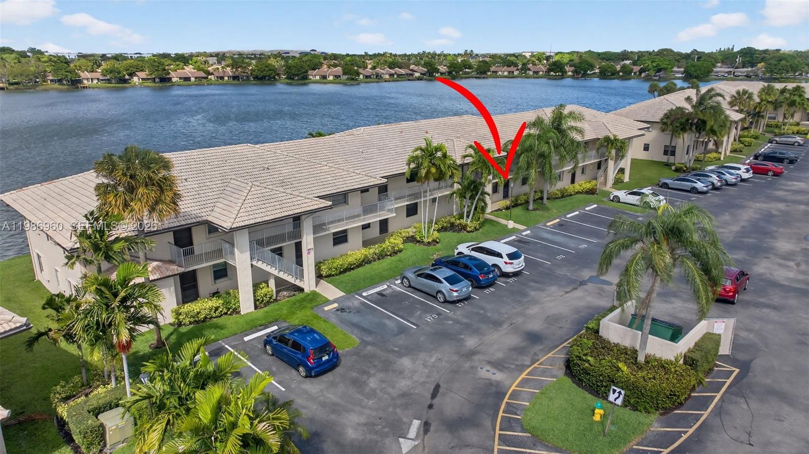 An aerial view shows a multi-story apartment building with a lake and parking lot — 5520 Lakeside Dr # 105, Margate FL 33063, MARGATE, FL