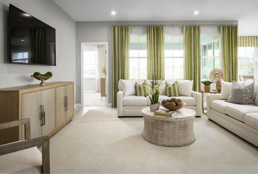 A living room features a white sofa, a round coffee table, and green striped curtains — 22141 PINE GROVE LOOP, LEESBURG, FL