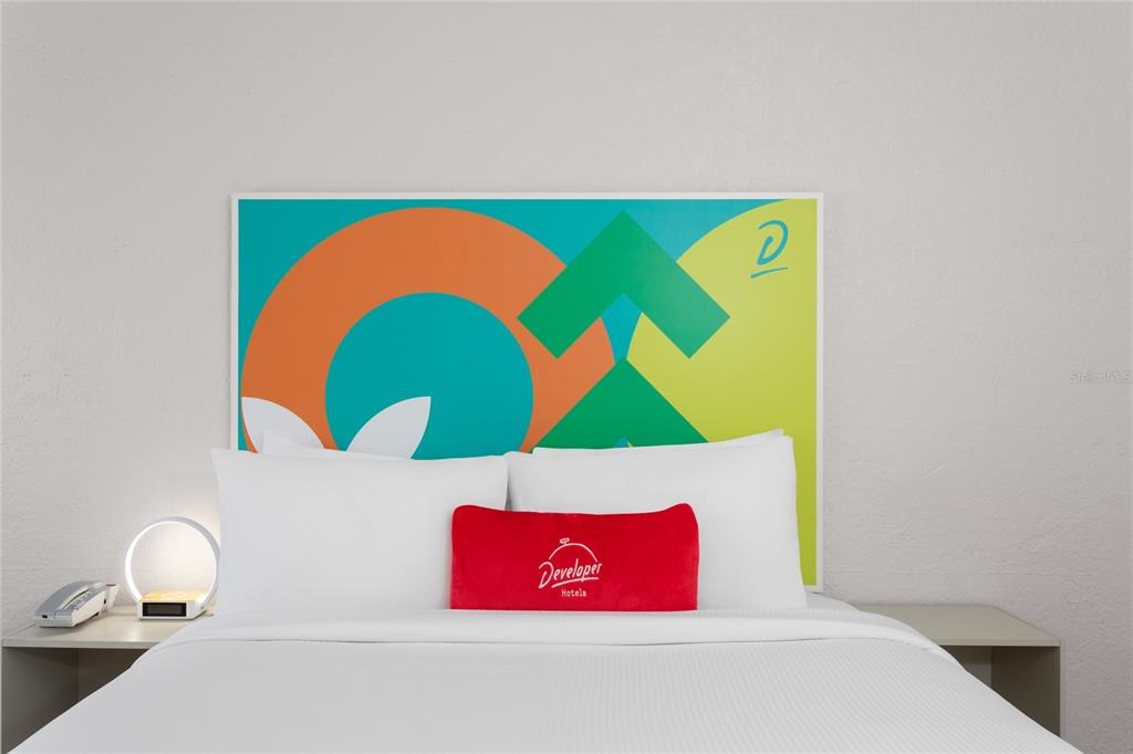 A hotel room features a bed with a colorful abstract headboard and a red pillow — 5367 W IRLO BRONSON MEMORIAL HIGHWAY UNIT 2-219, KISSIMMEE, FL