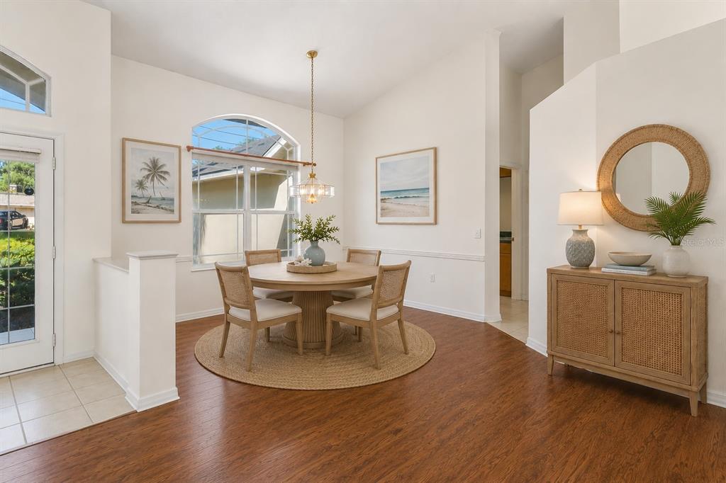 A dining area features a round wooden table, four cane chairs, and a rattan sideboard — 6381 PINEHURST DRIVE, SPRING HILL, FL
