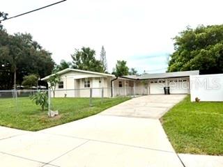 A single-story house with a white exterior, a two-car garage, and a concrete driveway — 2410 LANDO LANE, ORLANDO, FL