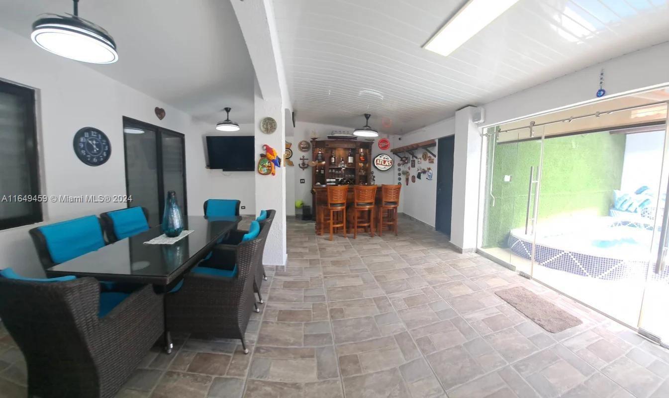 This covered patio area features a dining set, a built-in bar, and a hot tub — 56-D Versalles I - Panama City, PA Panama, PA