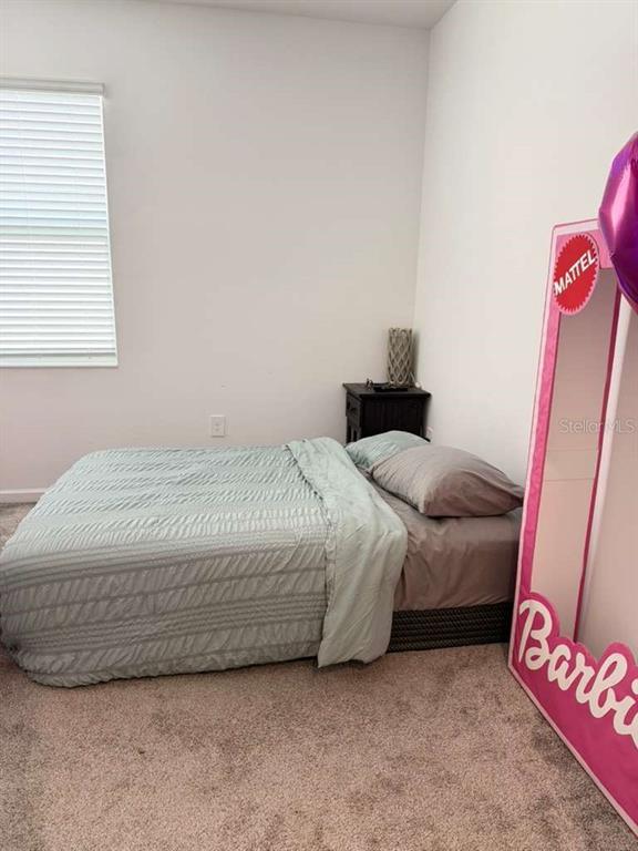 A bedroom features a bed with a light green comforter and a Barbie-themed prop — 1103 POMELO STREET, DAVENPORT, FL