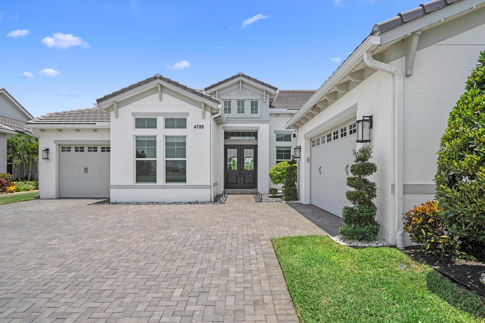 A single-story house with a paved driveway, two garage doors, and a central front entrance — 4788 Estates Circle, Westlake FL 33470, WESTLAKE, FL