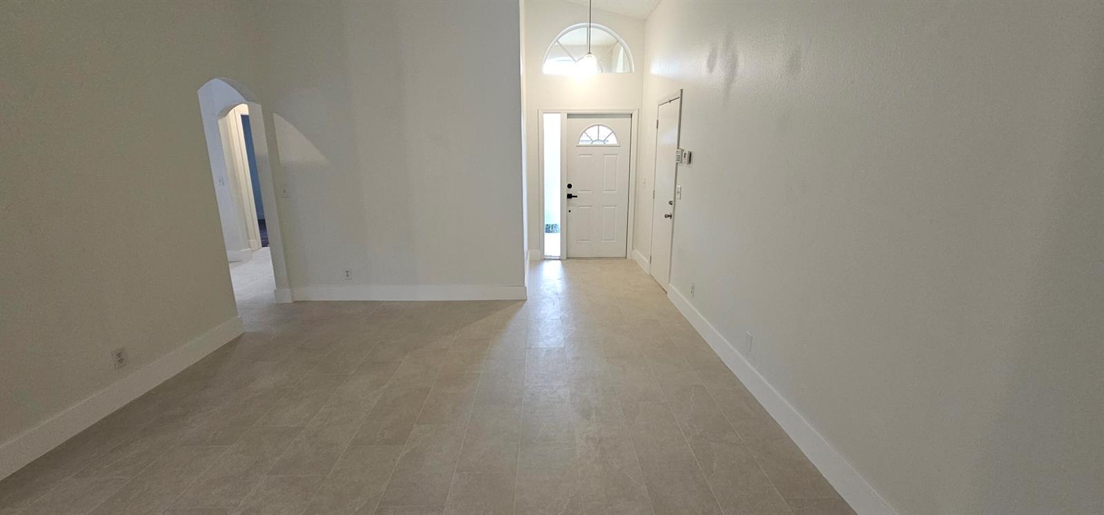 An entryway with light-colored tile flooring leads to a white front door with a transom — 10780 Cypress Lake Terrace, Boca Raton FL 33498, BOCA RATON, FL