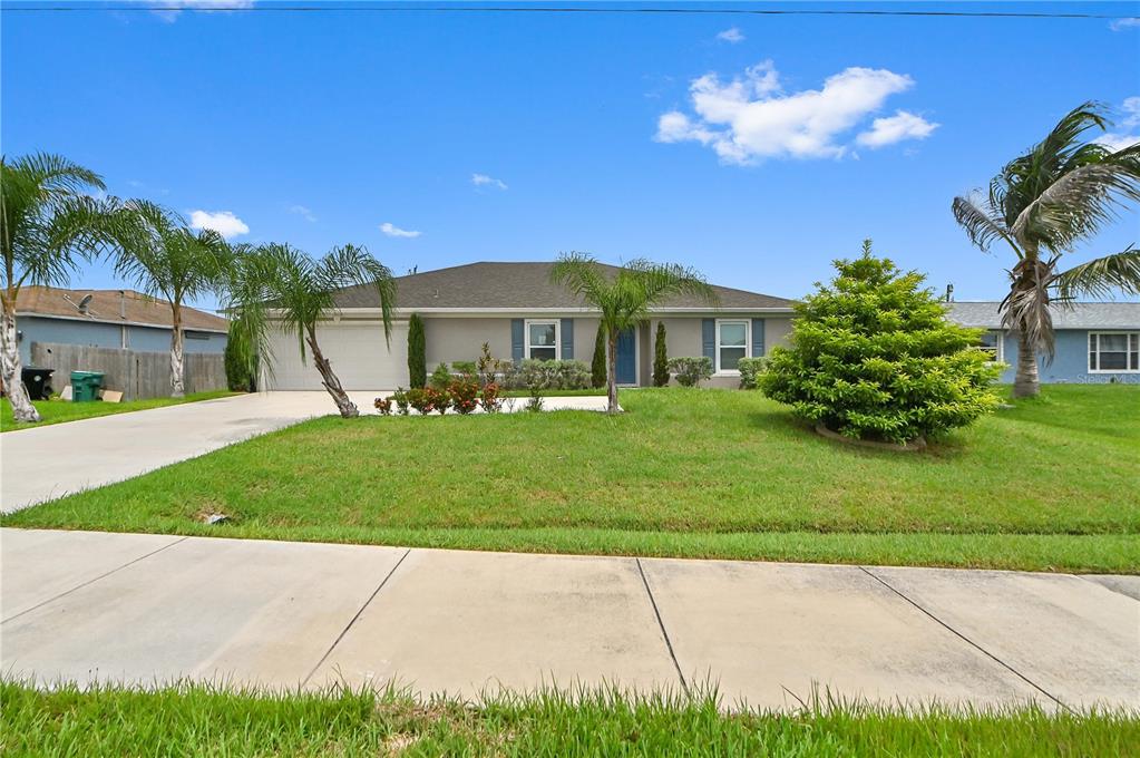 A single-story house with a gray exterior, a two-car garage, and a front lawn — 361 SW THORNHILL DRIVE, PORT ST LUCIE, FL