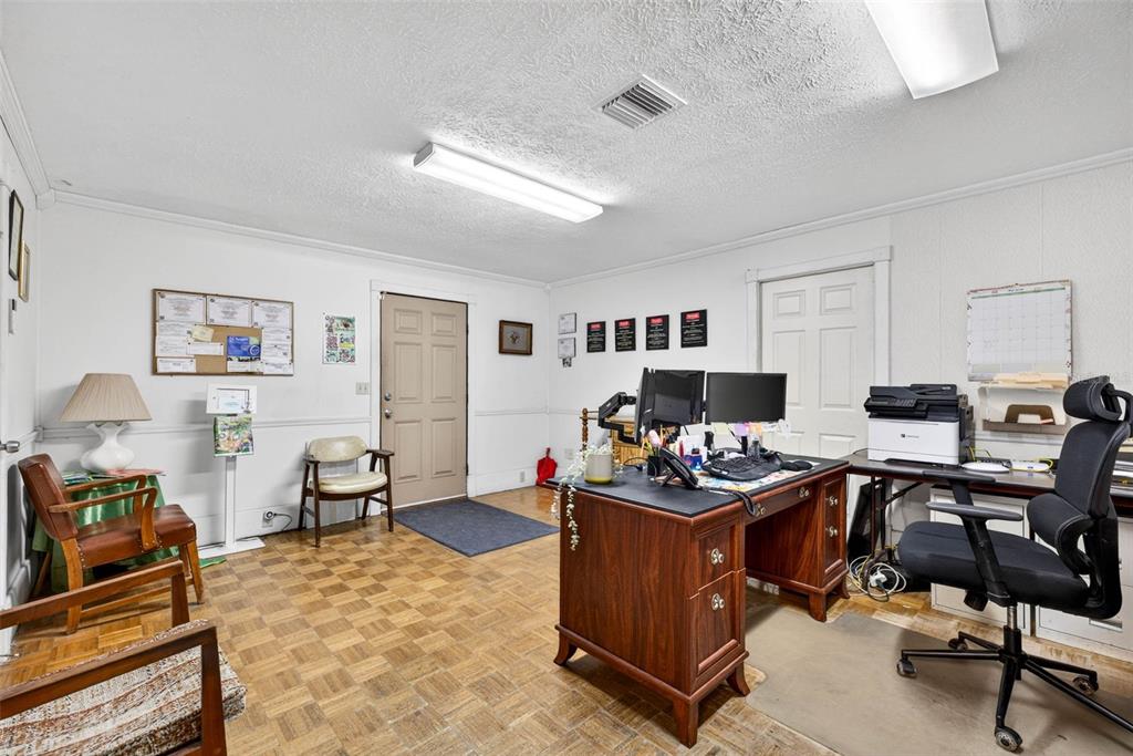 An office room features wood parquet flooring, a wooden desk, and a rolling chair — 10221 US HIGHWAY 301, DADE CITY, FL