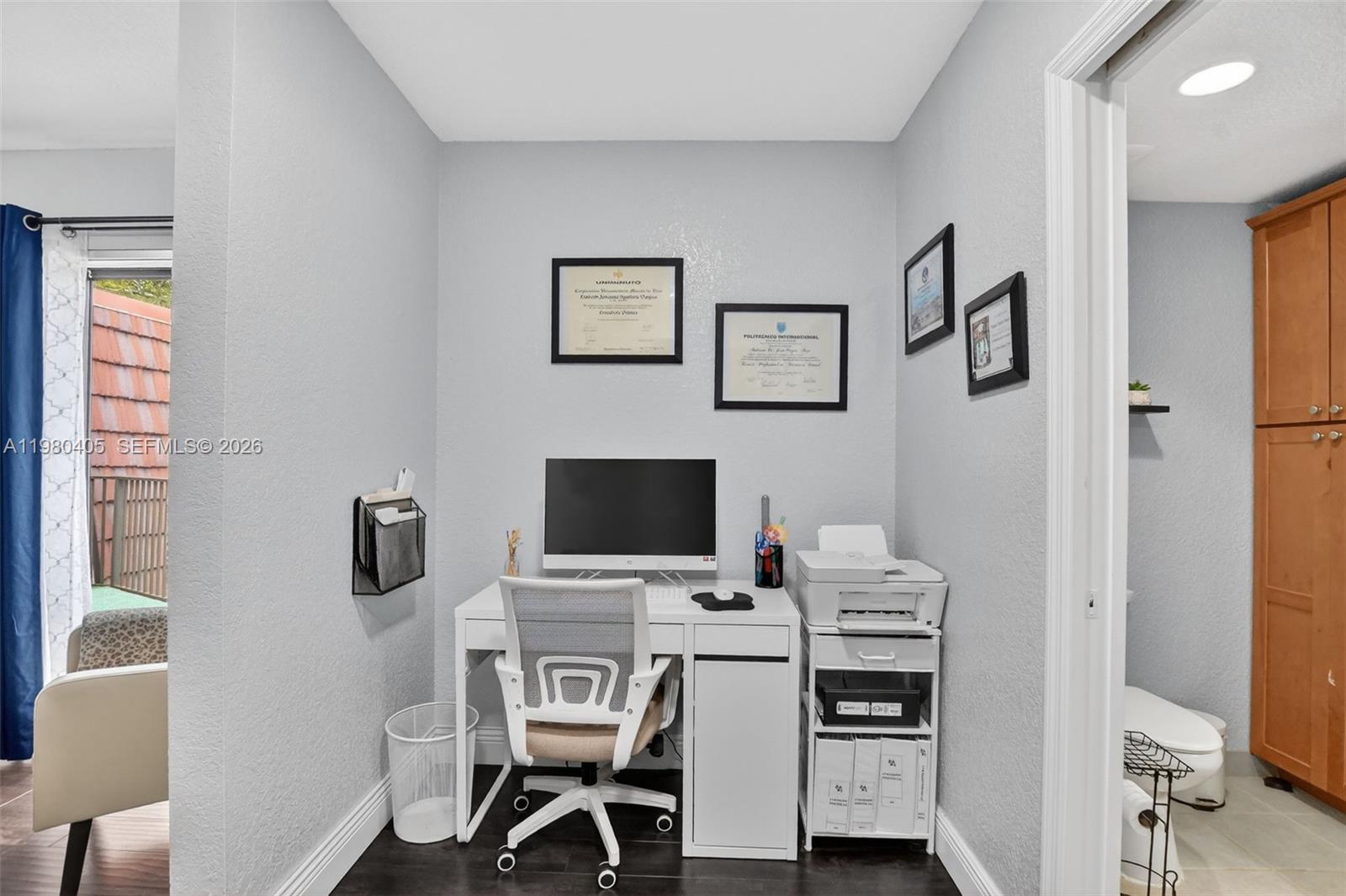 A small home office features a white desk, computer, printer, and framed diplomas on the wall — 8181 Boca Rio Dr # 8181, Boca Raton FL 33433, BOCA RATON, FL