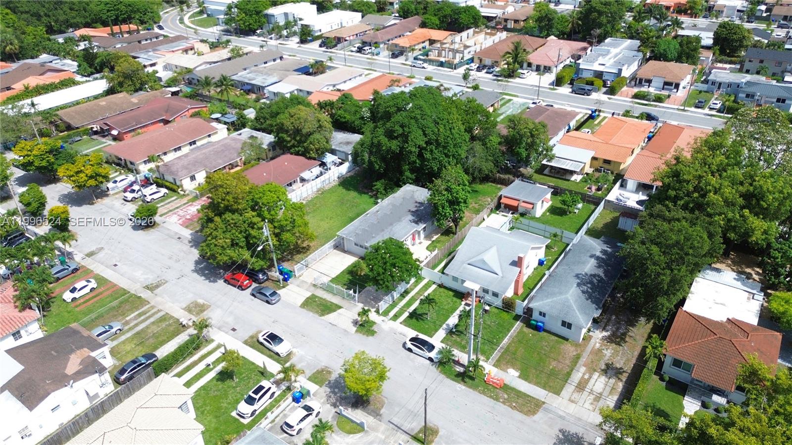An aerial view shows a residential neighborhood with single-family homes, green trees, and parked cars — 3121-3123 SW 25th Ter, Miami FL 33133, MIAMI, FL