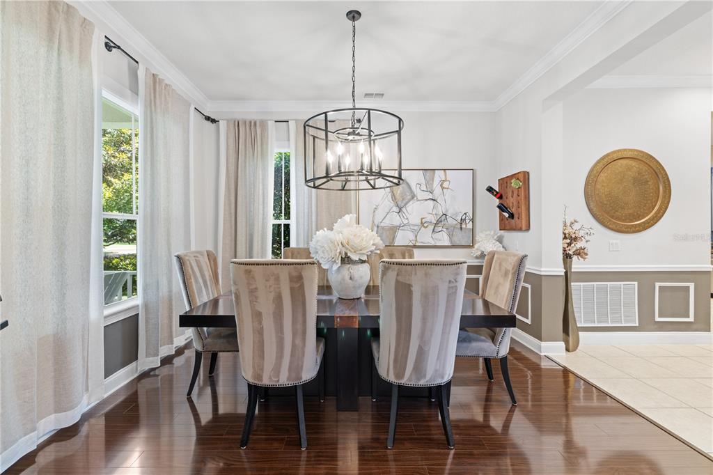 A covered front porch features light wood-look tile flooring, white railings, and two white chairs — 11617 CAMDEN PARK DRIVE, WINDERMERE, FL
