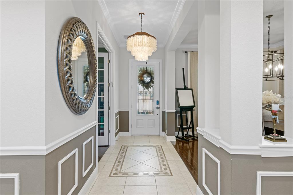 A formal dining room features a dark wood table, upholstered chairs, and a metal chandelier — 11617 CAMDEN PARK DRIVE, WINDERMERE, FL