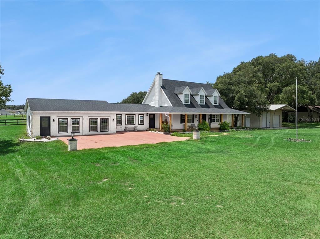 A white brick house with a dark shingled roof and a large front lawn — 160 JUNIPER TRAIL, OCALA, FL